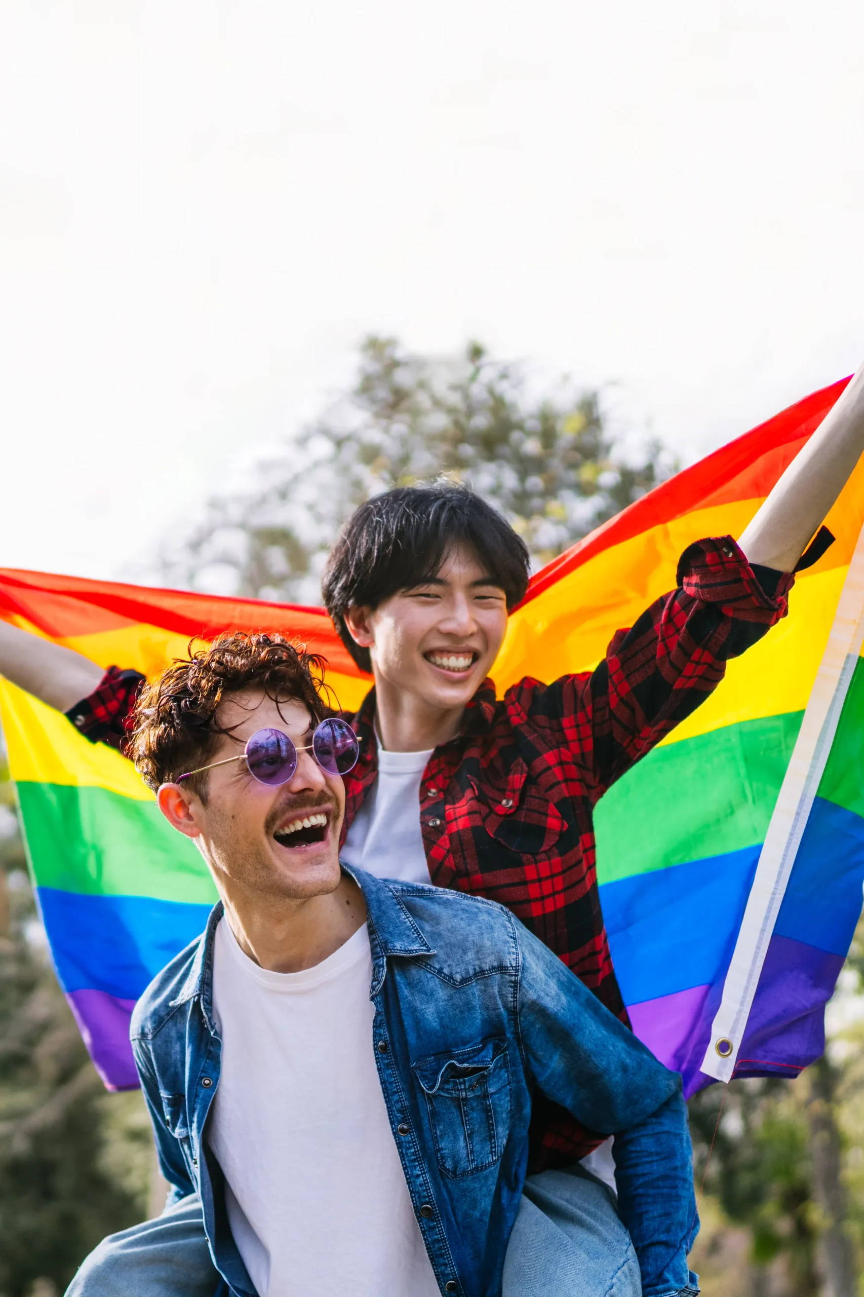 Office meeting with three people in front of a rainbow working at a desk.