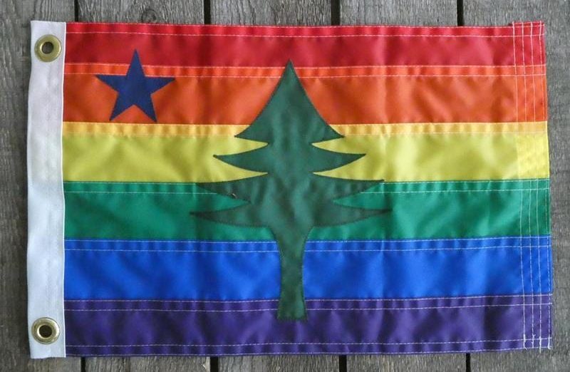 Rainbow pride flag with the Maine state flag pine tree emblem.