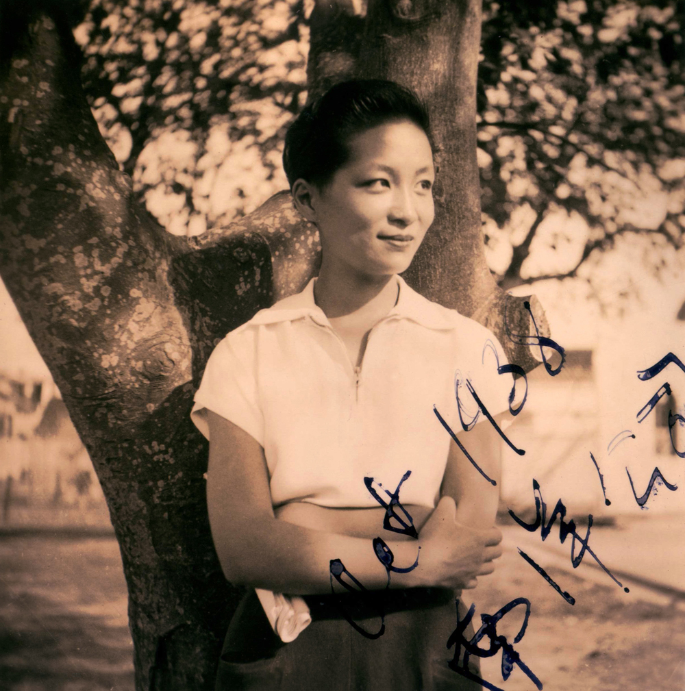 Eng, Esther Queer, Chinese-American filmaker Esther Eng, with a pixie cut and white collared blouse, in front of a tree.