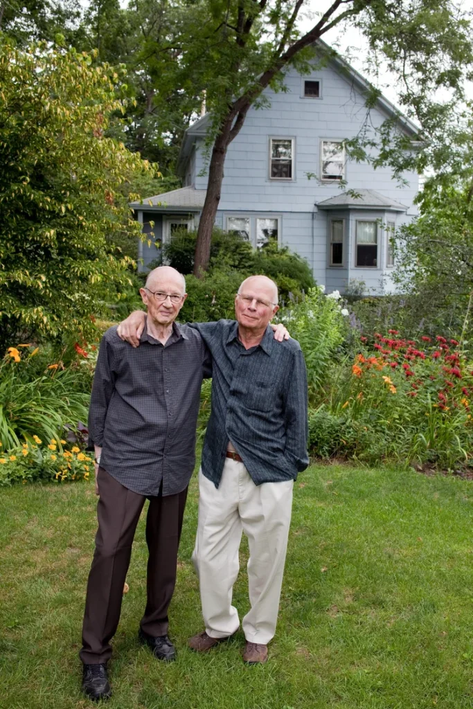 Gay artists John O’Reilly & James Tellin, two older white men, standing in their garden